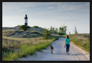 young woman walking to the big sable lighthouse in Ludington state park